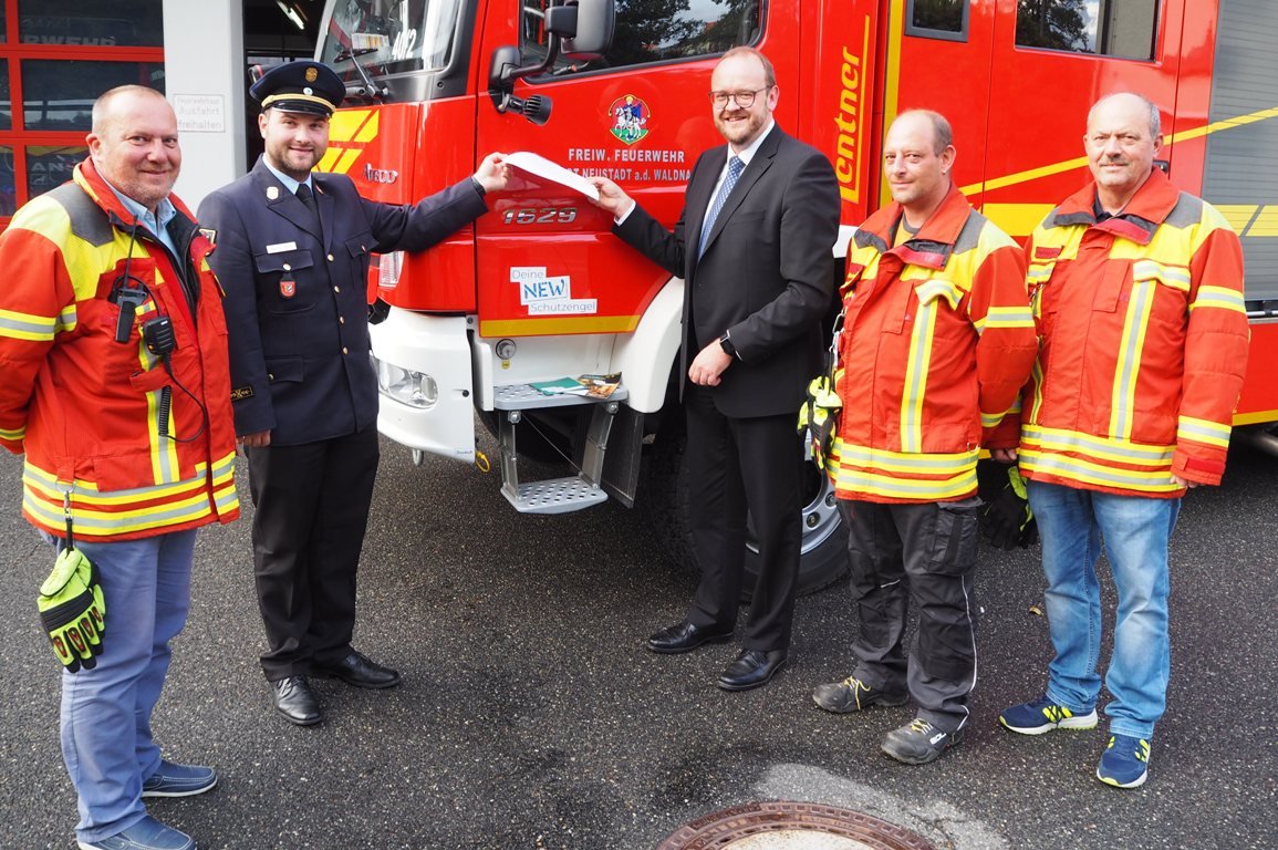 Michael Spranger, Kreisbrandrat Marco Saller, Landrat Andreas Meier, stellvertretender Kommandant Marco Harrer und Vorsitzender des Neustädter Feuerwehrvereins Helmut Staratschek enthüllen den ersten „Deine NEW Schutzengel“-Aufkleber. Bild: Bernhard