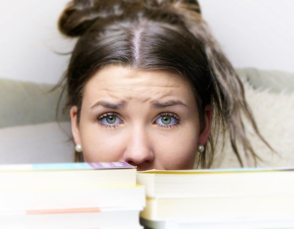 Schule lernen Prüfung Klausur Studium Abschluss Mädchen Frau Symbolbild unsicher Buch Bücher