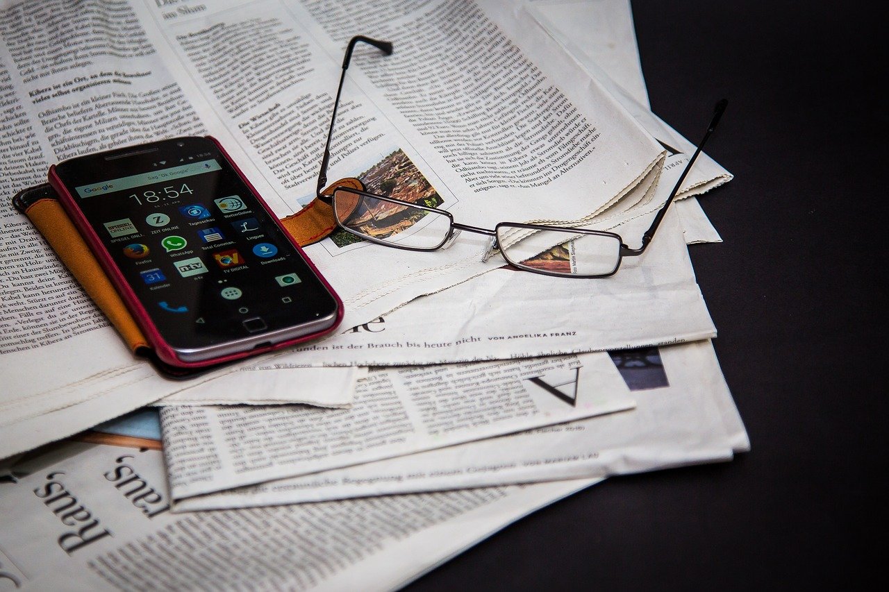Zeitung, Handy, Brille Symbolbild