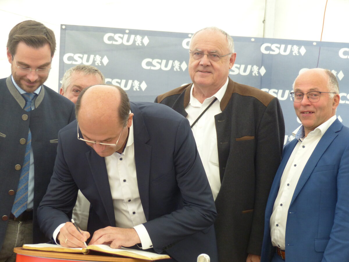 Minister Füracker trägt sich in Neudorf ins Goldene Buch ein